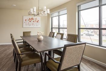 A dining room with a brown table and chairs.